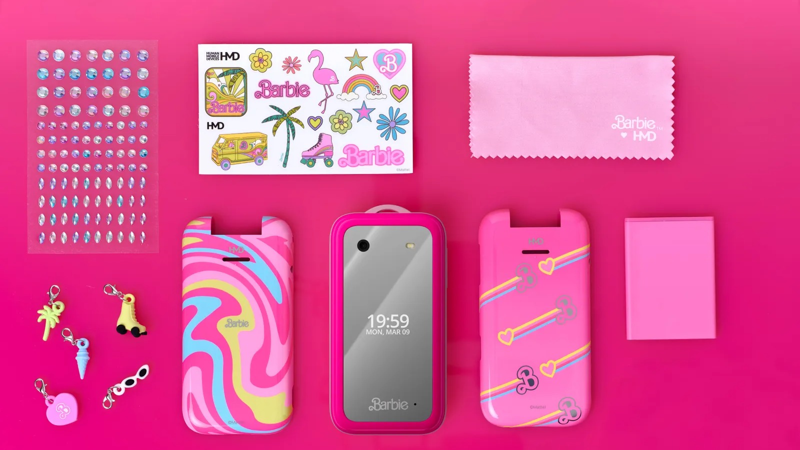 The Barbie flip phone and accessories on a pink table with the front display showing the time.