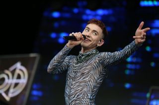 Olly Alexander performing on stage. 