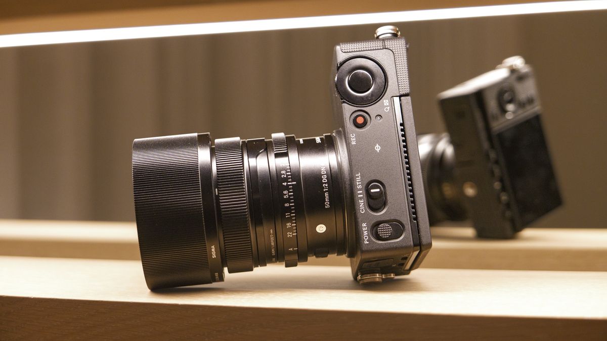 Sigma FP2 mirrorless camera with 50mm f/2 contemporary lenses attached, on a shelf, lit from above, view of its top plate