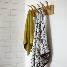 bathroom with wood wall hooks and towels