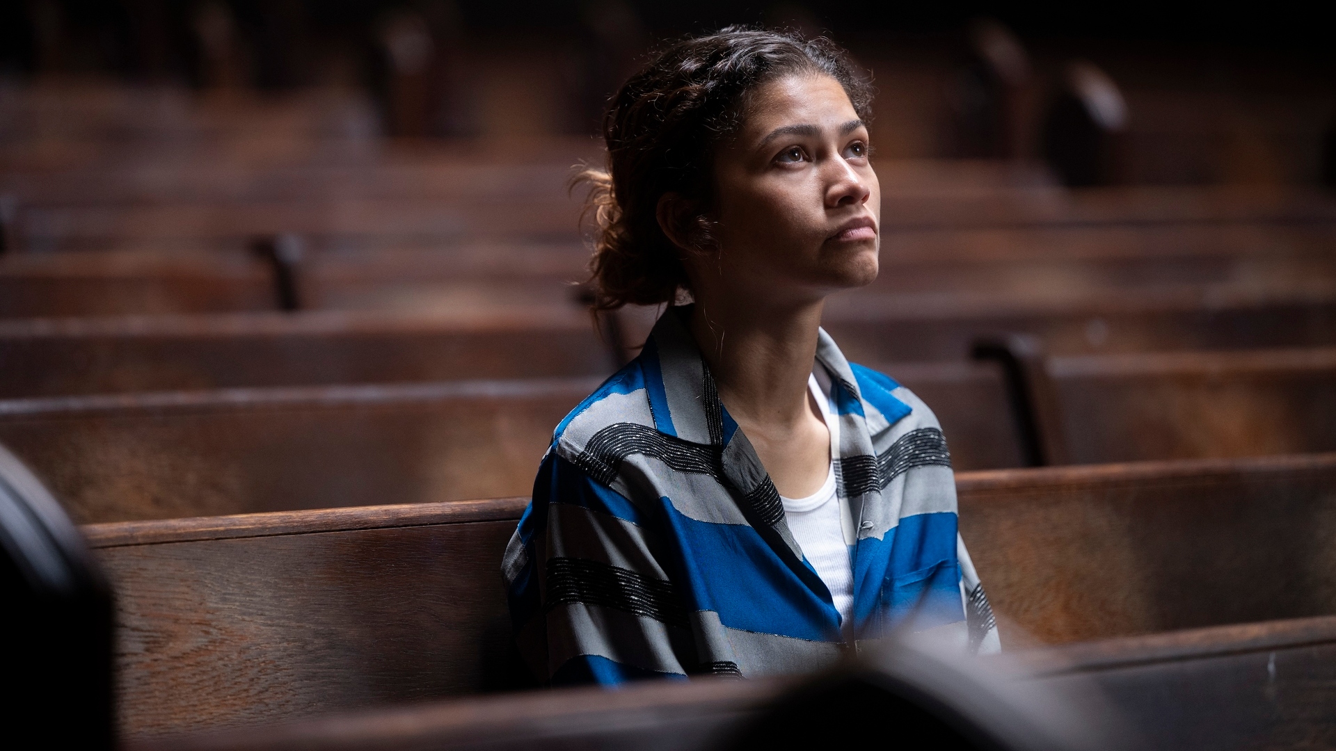 Zendaya as Rue sitting in a church and looking up at something.