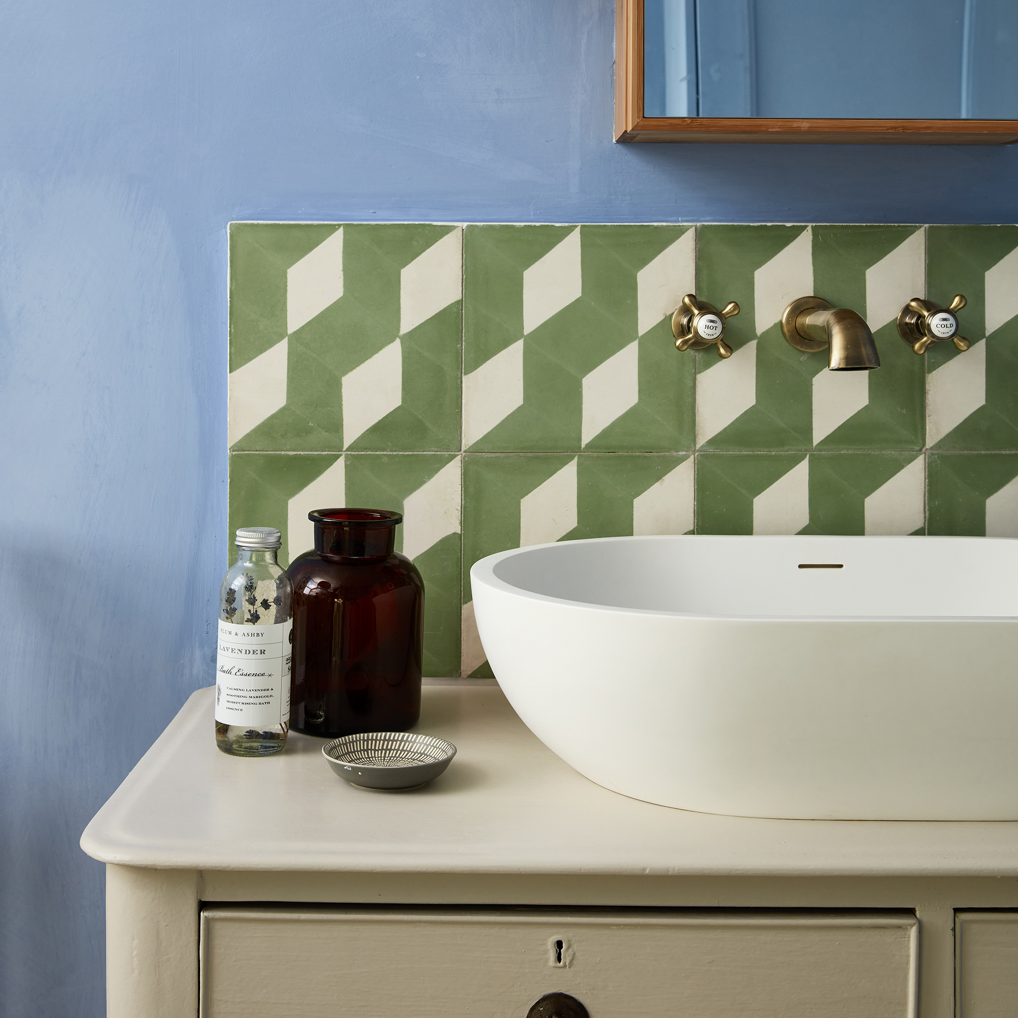 Batroom with half tiled green border around sink