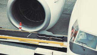 A guitar case is unloaded from a passenger jet