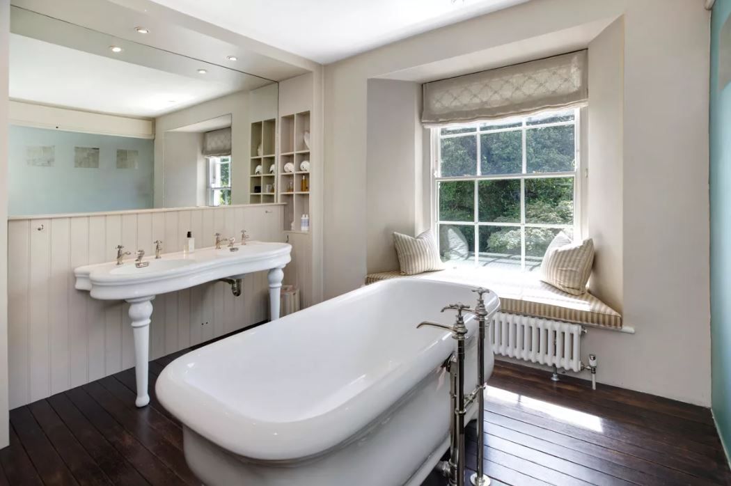 The bathroom with freestanding bathtub in the middle of the room and large vanity unit