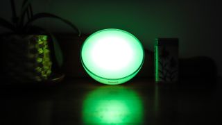 Philips Hue Go 2 displayed on table with green light