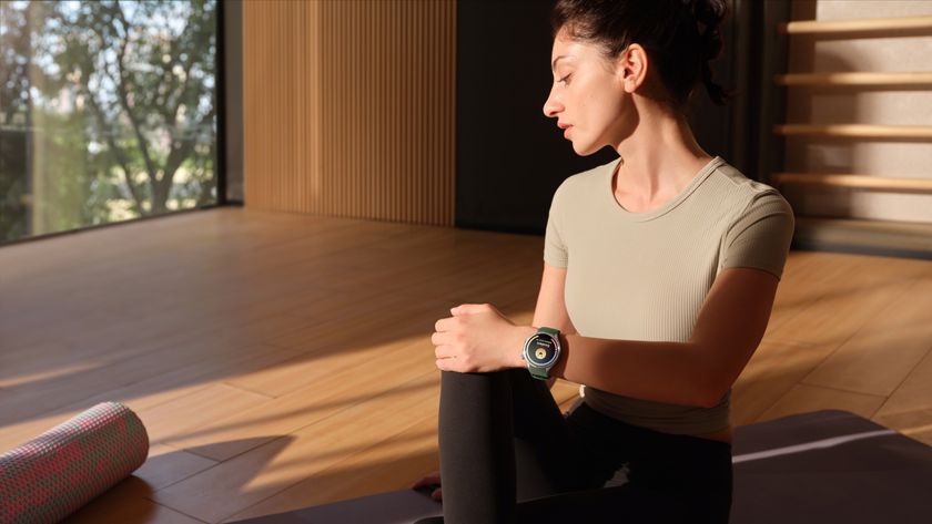 A relaxed woman on a yoga mat wearing a OnePlus Watch 3, showing an &quot;Excellent&quot; stress score with a smiling face.