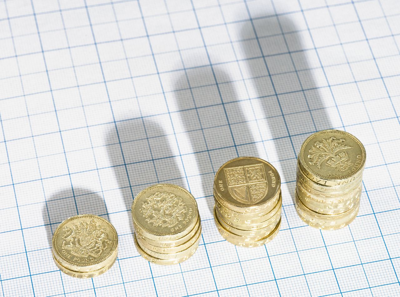 Rising stacks of British Pound coins representing National Living Wage concept