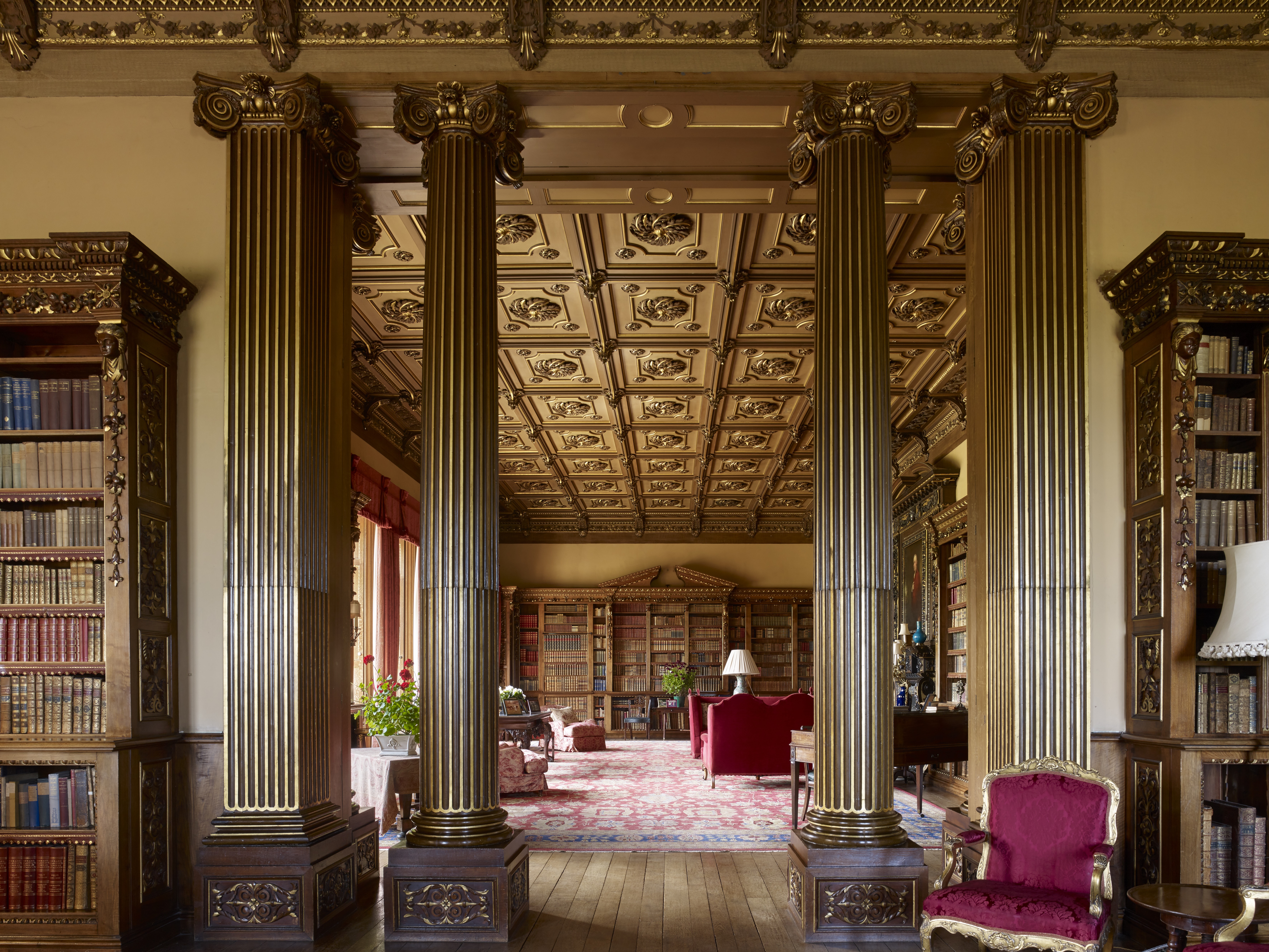Doric columns and pilasters splitting a two-room library with wooden shelves