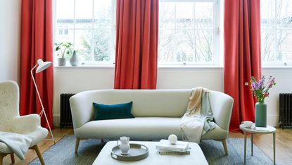 Red color pop curtains in neutral living room scheme.