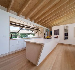 White kitchen counters, wooden flooring and ceiling