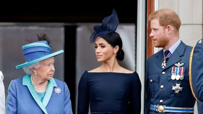 Queen Elizabeth II, Meghan, Duchess of Sussex and Prince Harry, Duke of Sussex watch a flypast to mark the centenary of the Royal Air Force from the balcony of Buckingham Palace on July 10, 2018 in London, England