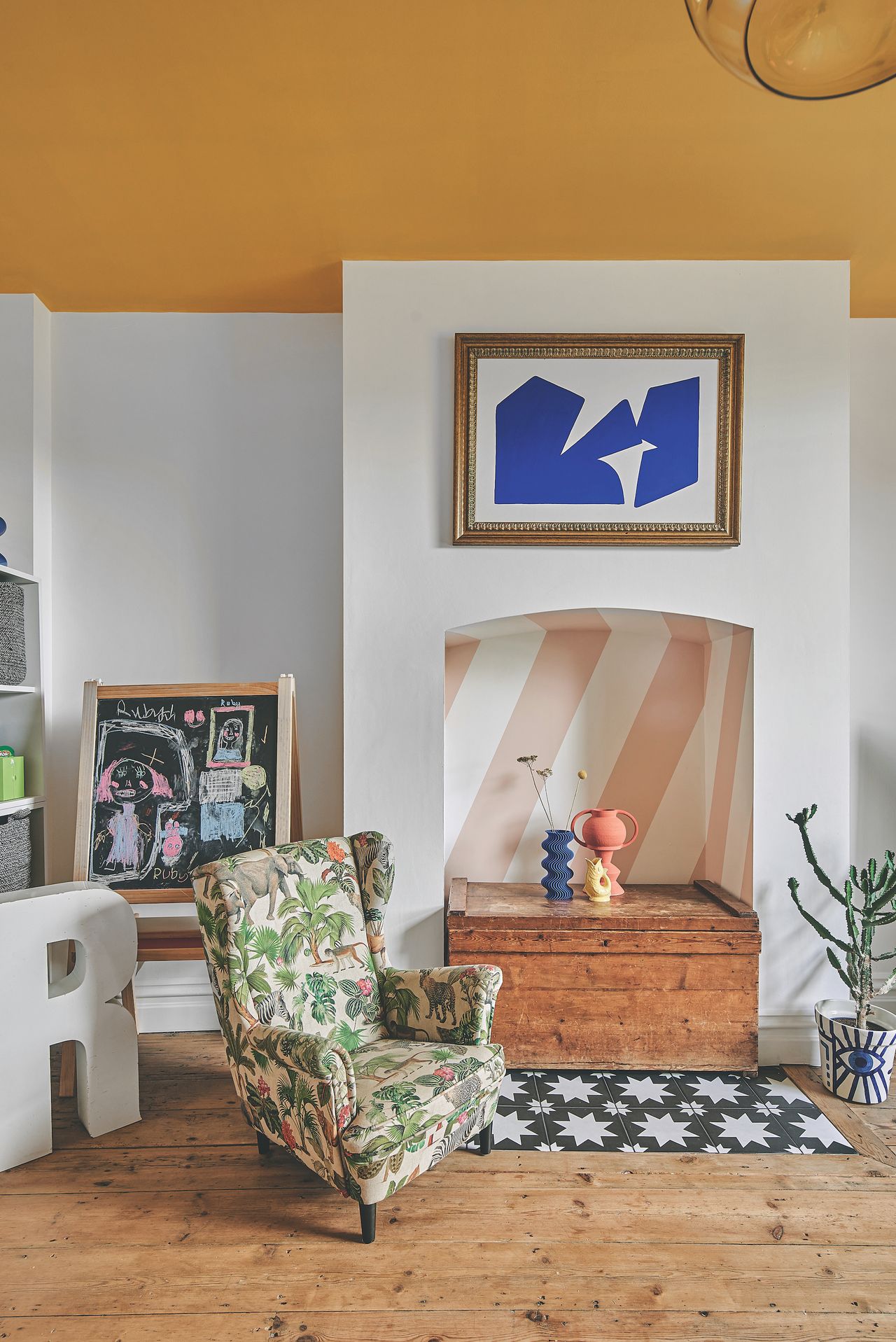 childrens bedroom with empty fireplace and wooden flooring