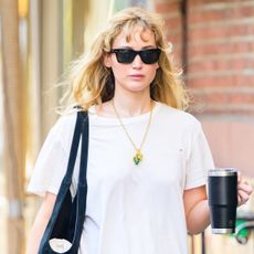 Jennifer Lawrence wearing a white T-shirt, low-rise bootcut jeans, and black tote, and black ballet flats in NYC