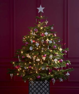 Decorated Christmas tree in front of painted paneling