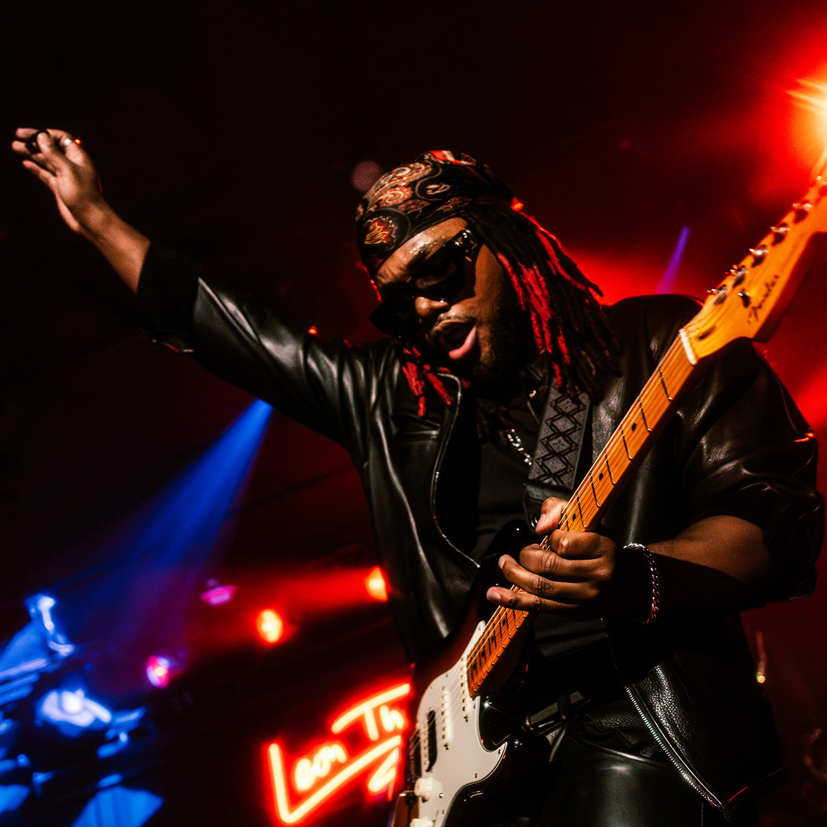 Leon Thomas playing a Fender Strat on stage