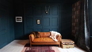 A sofa inside a room with a dark wall