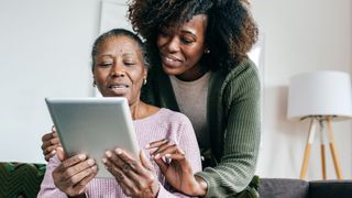 Daughter helping mother with iPad