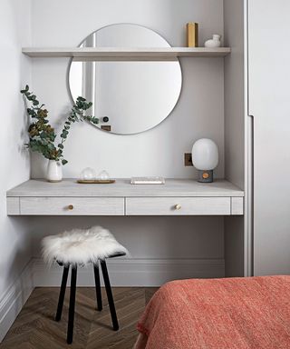Grey bedroom with small desk area and mirror