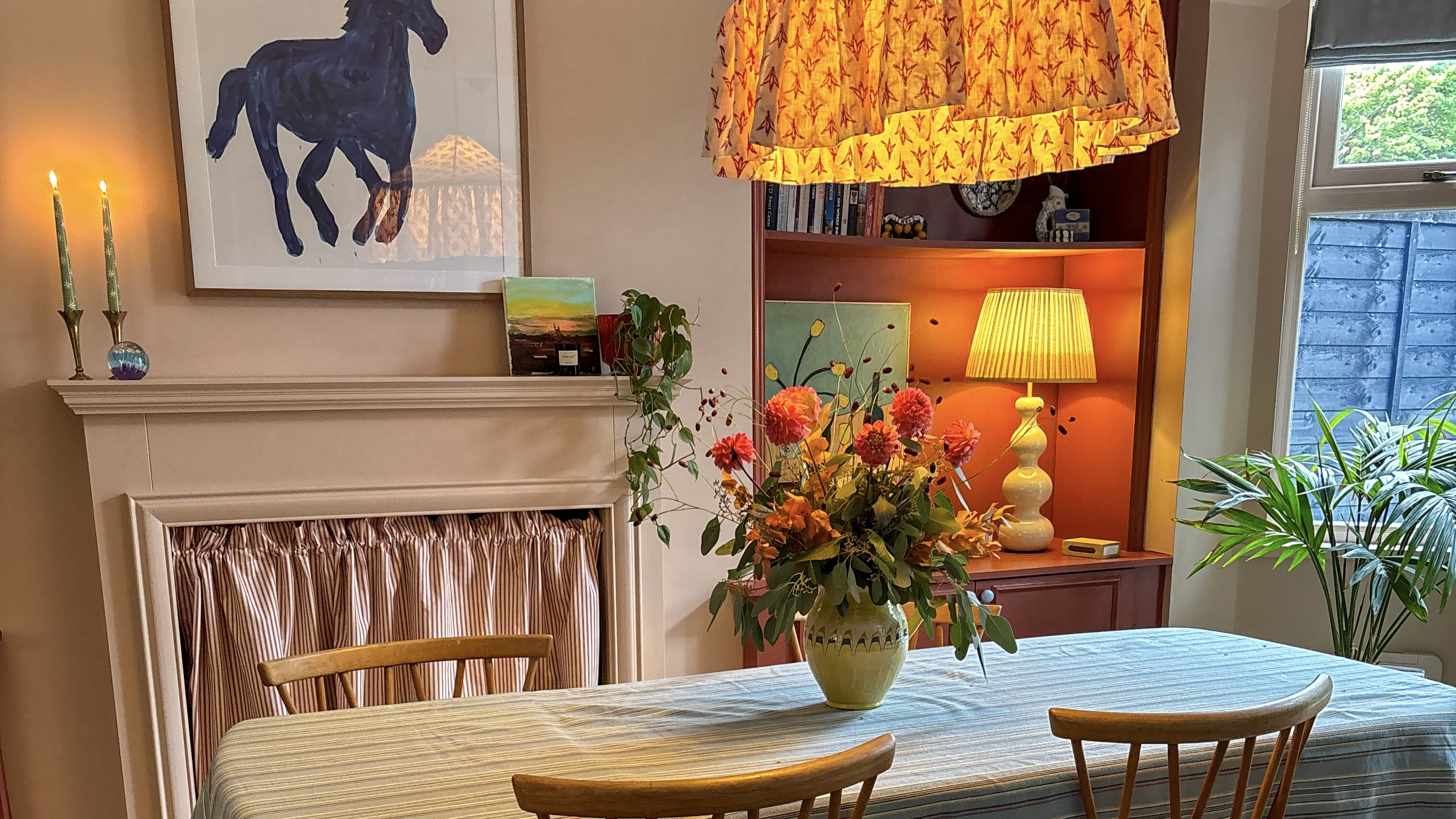 pink dining room with fabric light shades and wood chairs