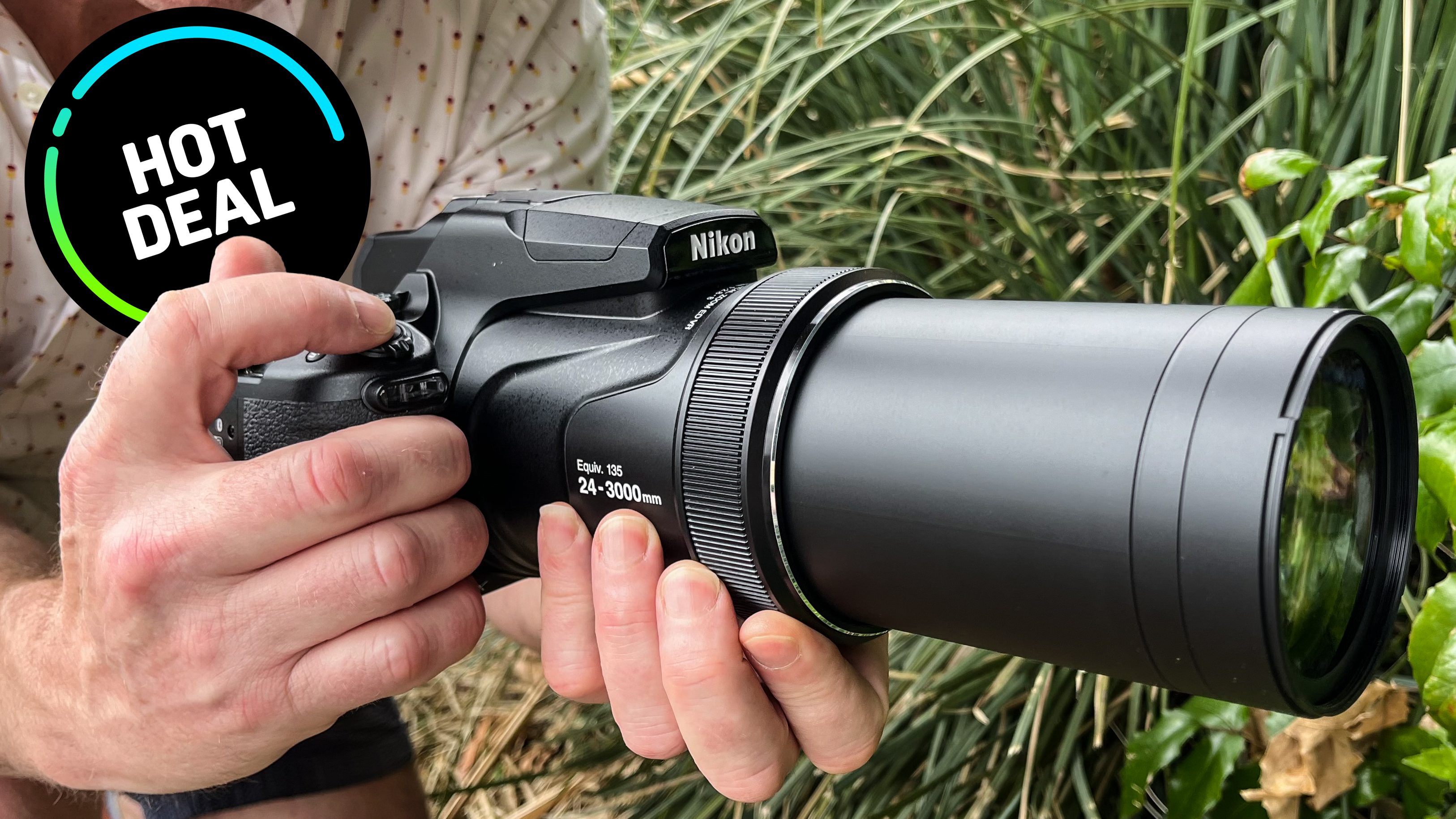 Nikon P1100 being held in someone&#039;s hands outdoor with great deal sticker