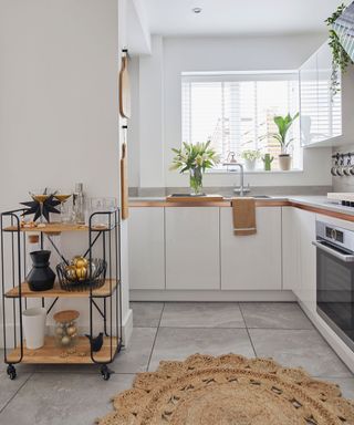 kitchen area with white wall and trolley with wheels