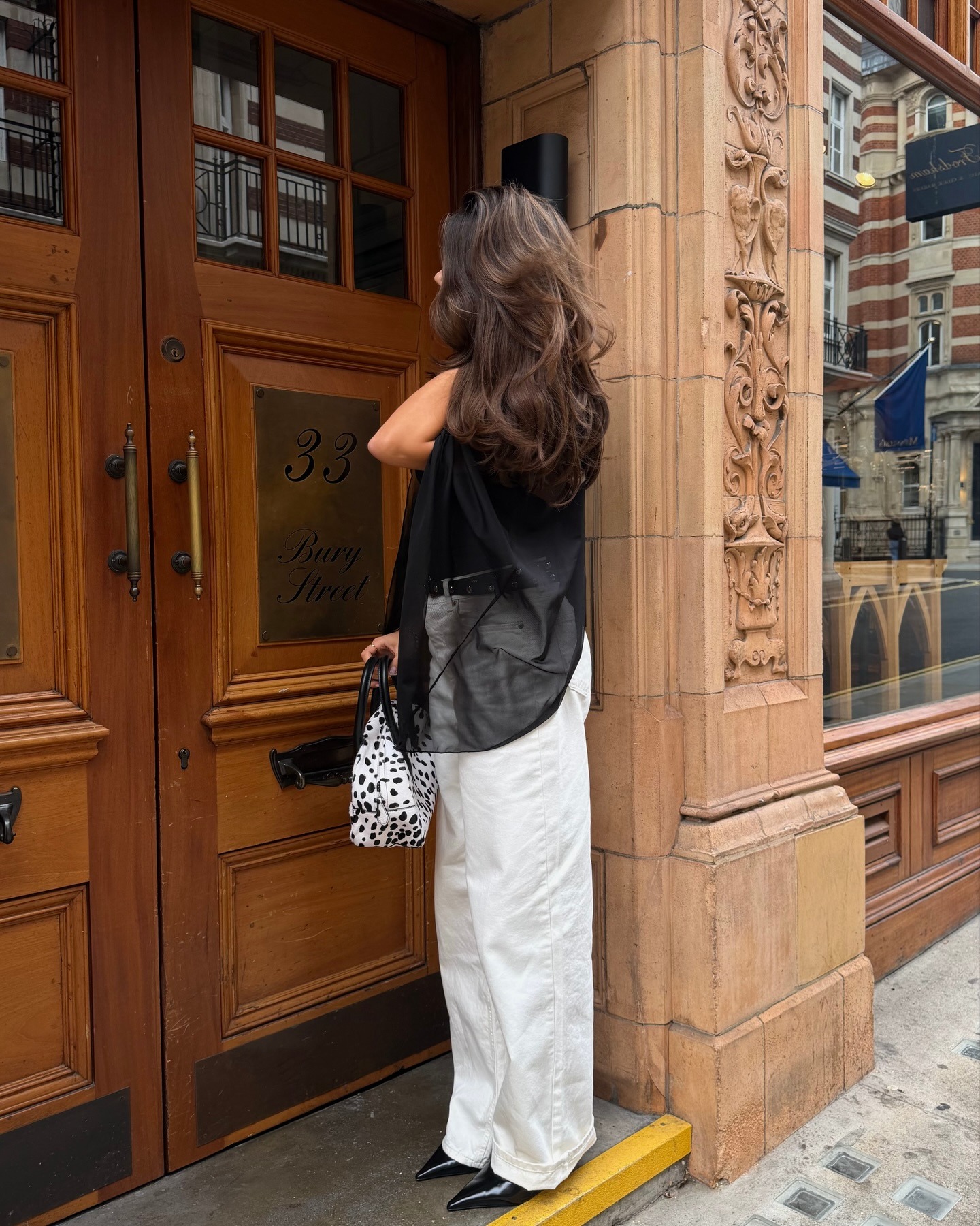 Fashion person Tia Dewitt shows a shoe to wear with baggy jeans. She wears white jeans an pointed-toe shoes.