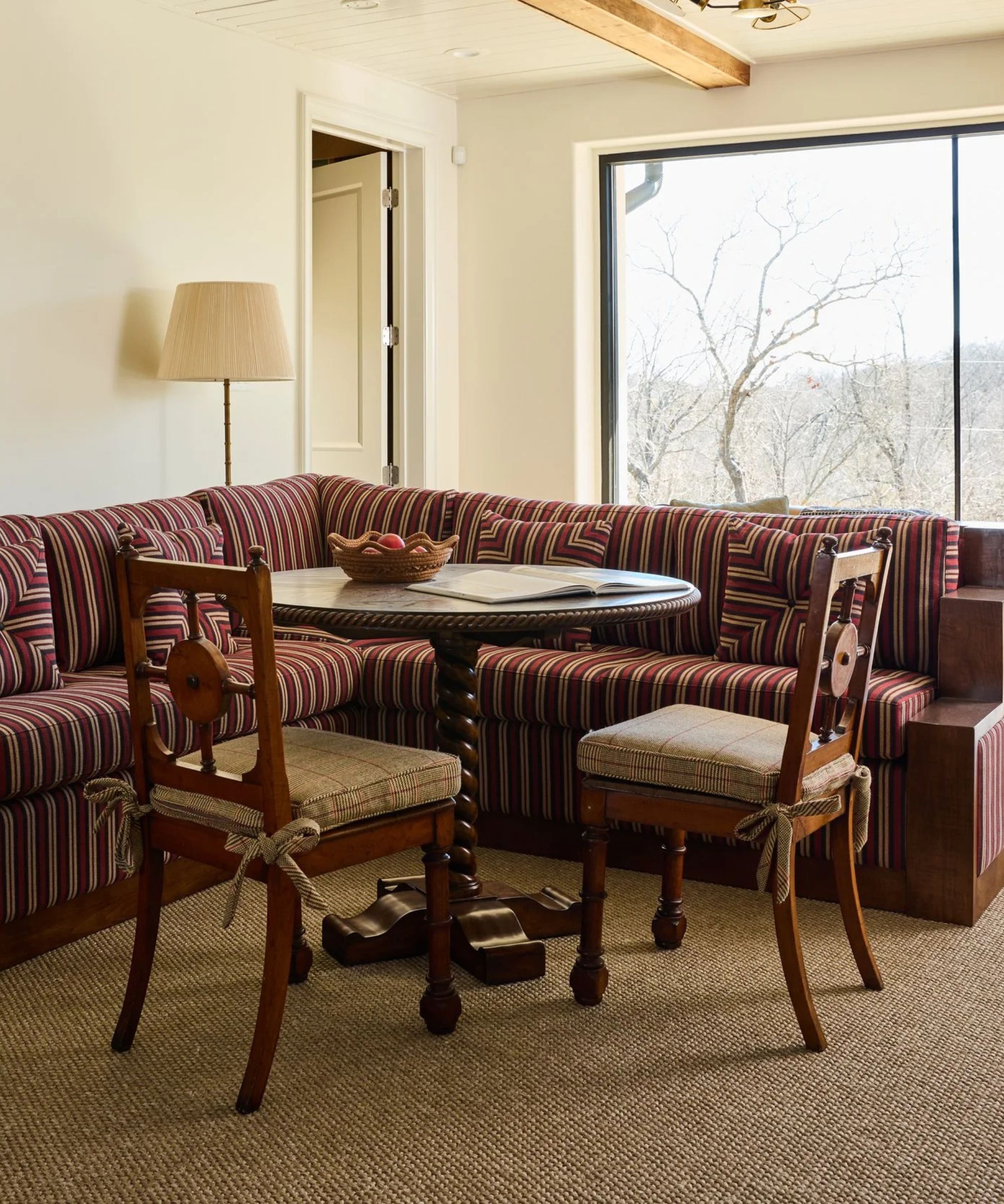 Burkle Creative custom banquette seating paired with a round table and antique dining chairs