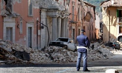 A policeman stands in front of collapsed buildings after an earthquake in Aquila, Italy, on April 7, 2009.