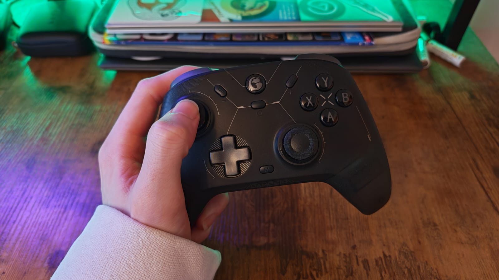 The GameSir Cyclone 2 being held in front of a gaming desk