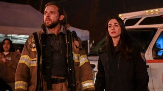 From left to right: Max Thieriot and Stephanie Arcila looking concerned on Fire Country.