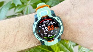 Close-up of the Garmin Instinct 3 showing the 'Torch' LED flashlight illuminated from the top of the watch case