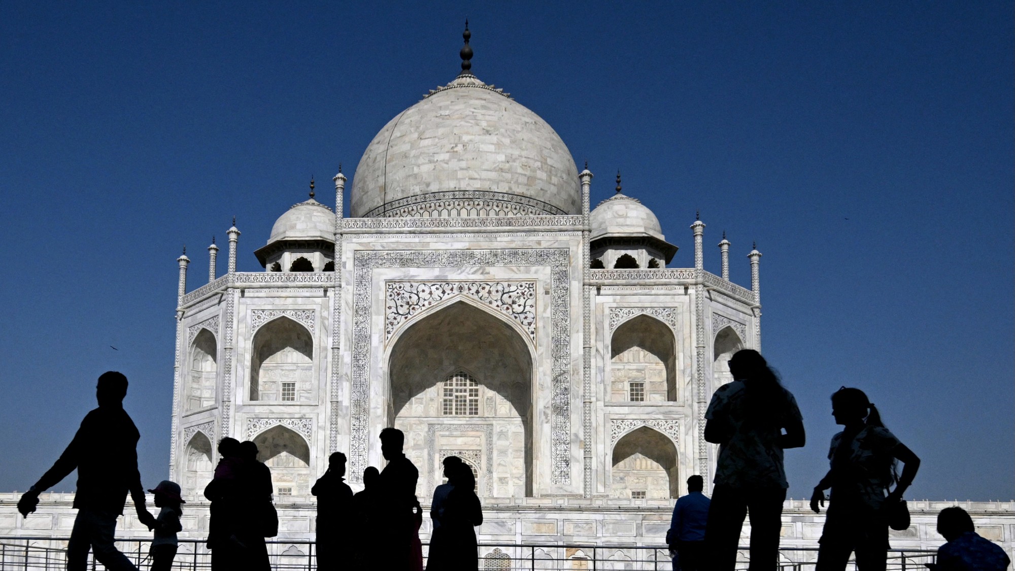 Visitors pass in front of the Taj Mahal in Agra, India.