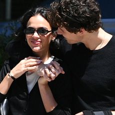 05/16/2026: Shawn Mendes and Bruna Marquezine in New York City. The Canadian singer and the Brazilian actress shared a kiss while heading to take a romantic waterfront stroll. Mendes wore a black sweater, jeans, and loafers. Marquezine wore a black cardigan, white lace skirt, and black loafers