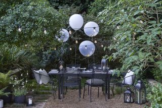 outdoor dining area decorated with balloons and festoon lights