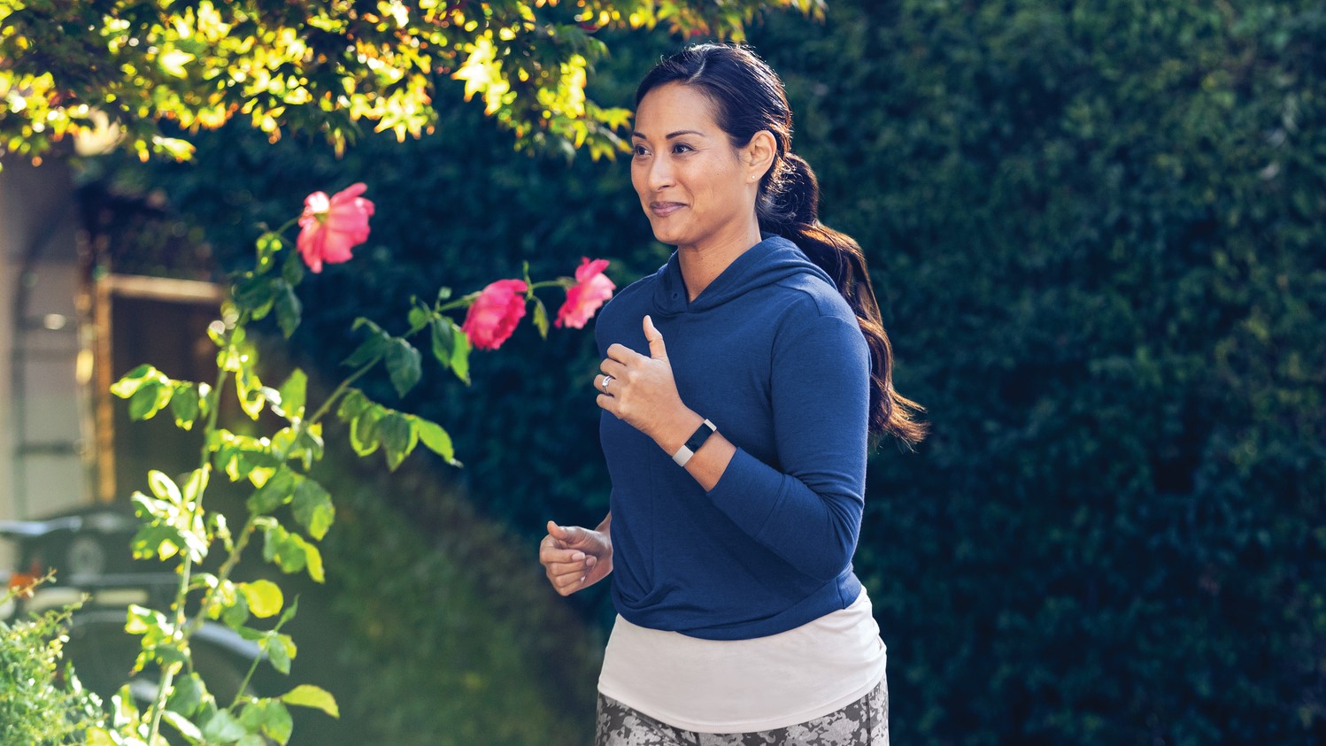 Woman jogging wearing Fitbit Inspire 2