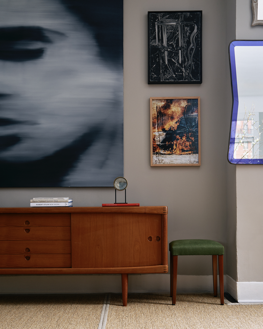 An image of Robert Stilin's shop, including a portrait of Stilin holding his latest book, an image of a wall with a credenza and hanging art, and a corner including an purple armchair and a couch.