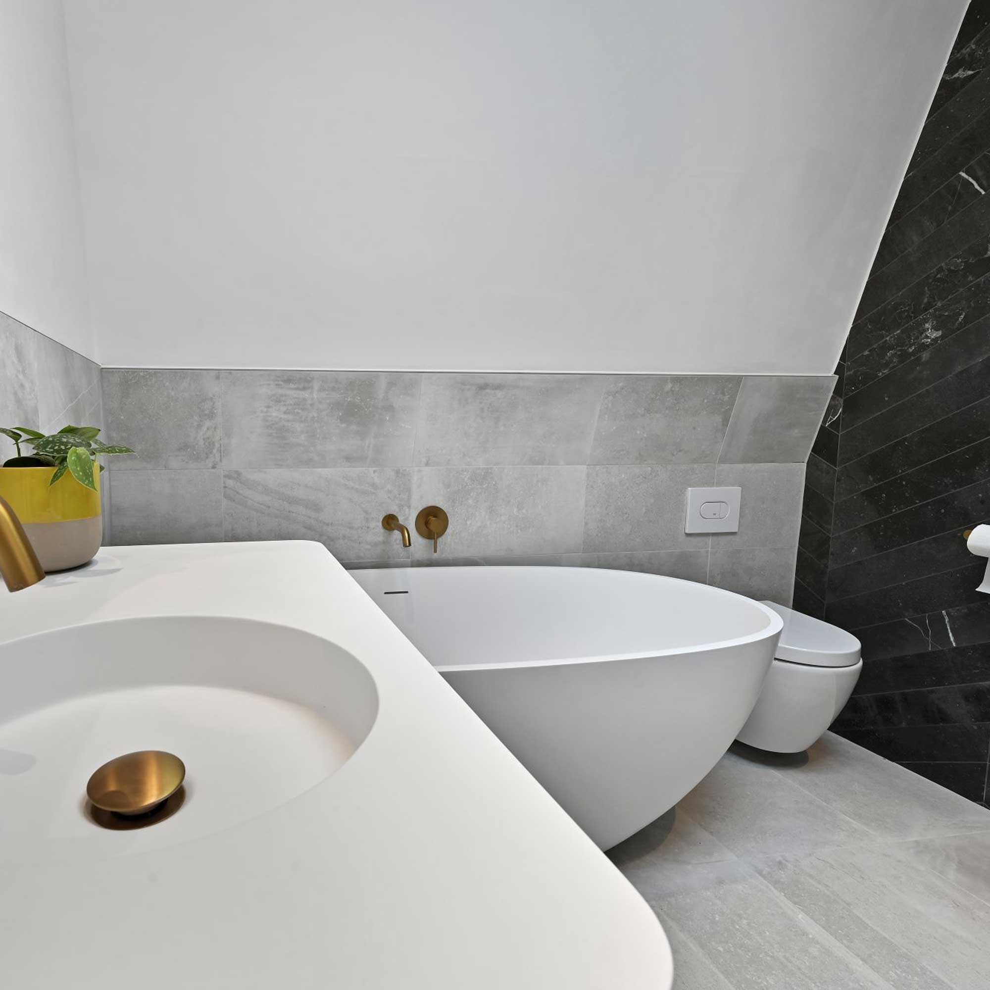 modern loft conversion bathroom with grey and black tiles
