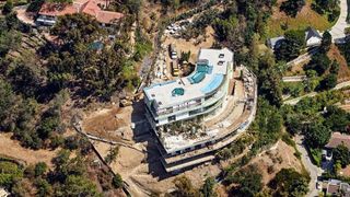 A large mansion in the final stages of construction as seen from the air.