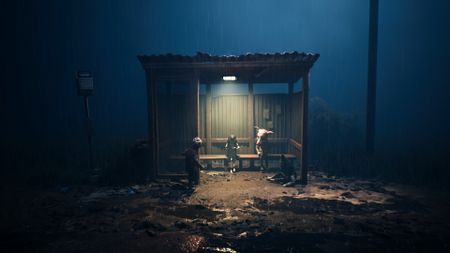 Three figures sit in a bus shelter