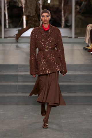 A runway model wears a F/W 2025 Tory Burch outfit.