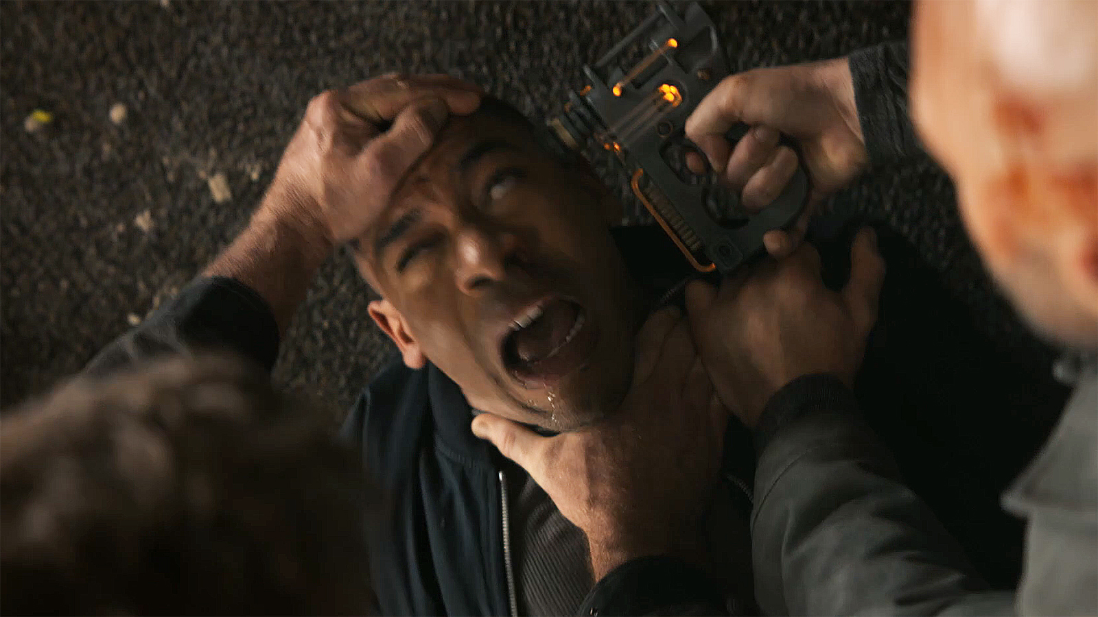 John Stewart in pain as he's held down by two men, one of whom is holding a device to Stewart's head in Lanterns episode 2