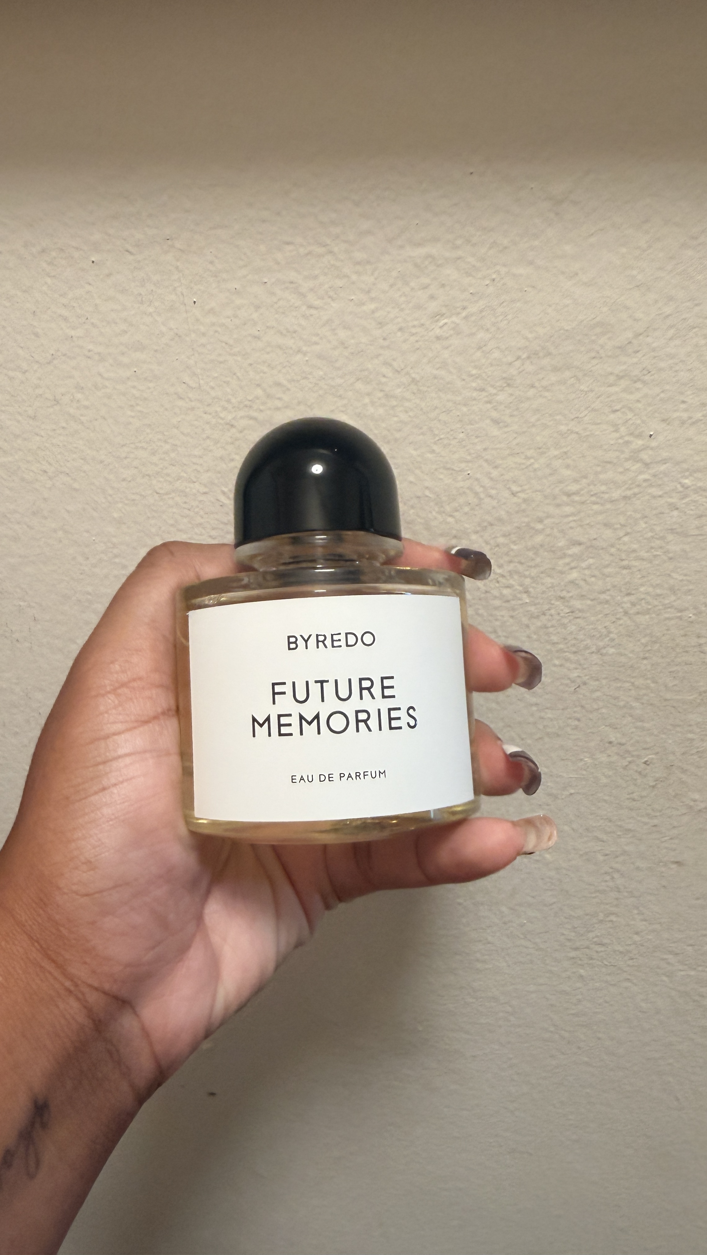 Ariel Baker holding a bottle of Byredo Future Memories