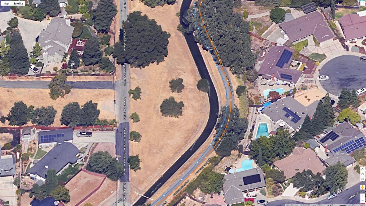 A Google Maps top-down view showing GPS lines for the Garmin Forerunner 970 (orange) and COROS PACE Pro (blue) indicating a running path.