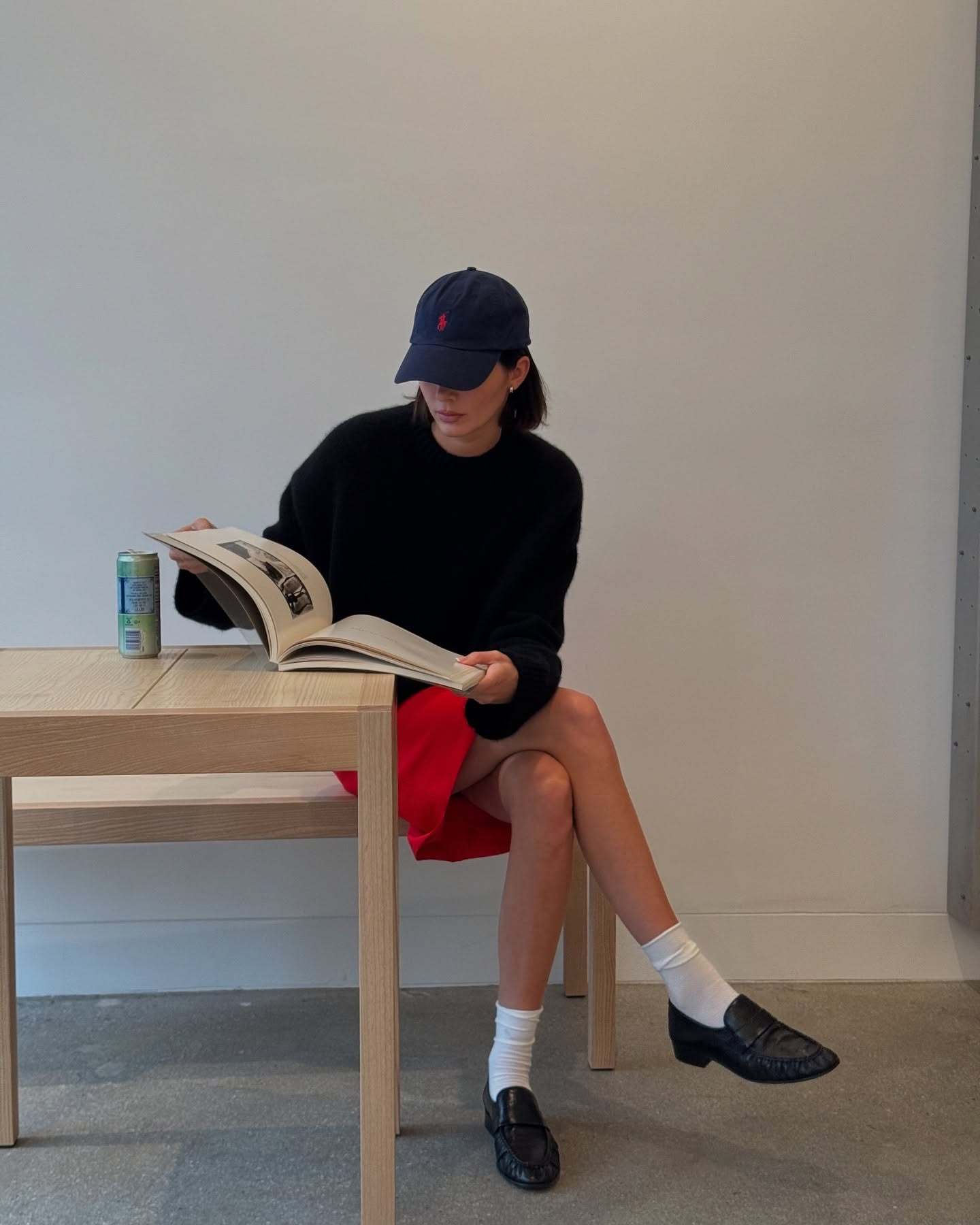 Kendall Jenner wearing a red mini skirt and black The Row patent leather loafers.