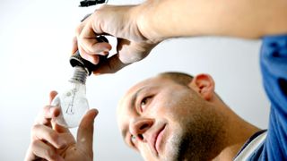 Man unscrewing light bulb 