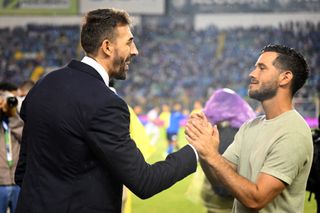 El Salvador coach David Dóniga greets Puerto Rico's Charlie Trout ahead of a match in June 2024.