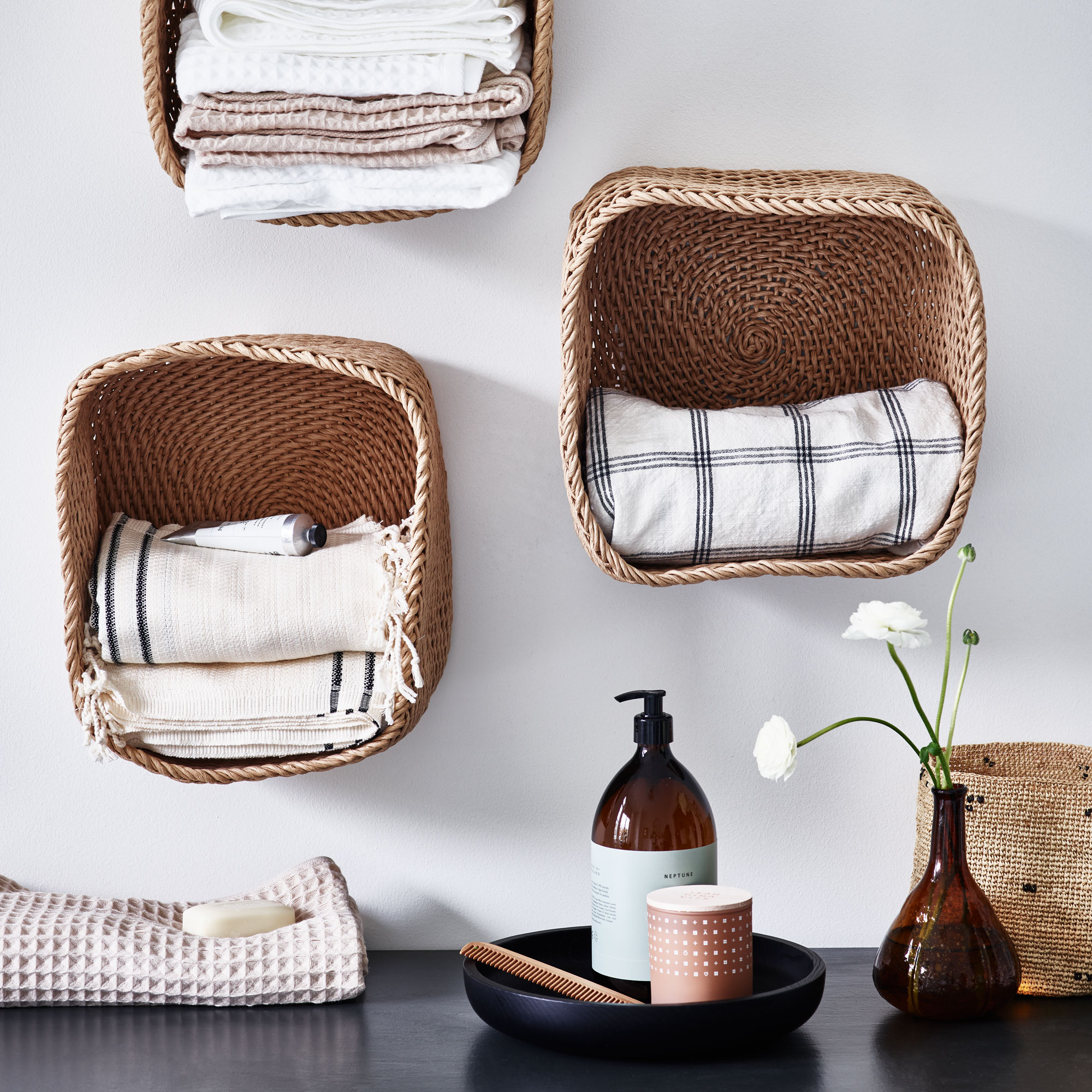 Baskets mounted on wall as shelves with plates of candles
