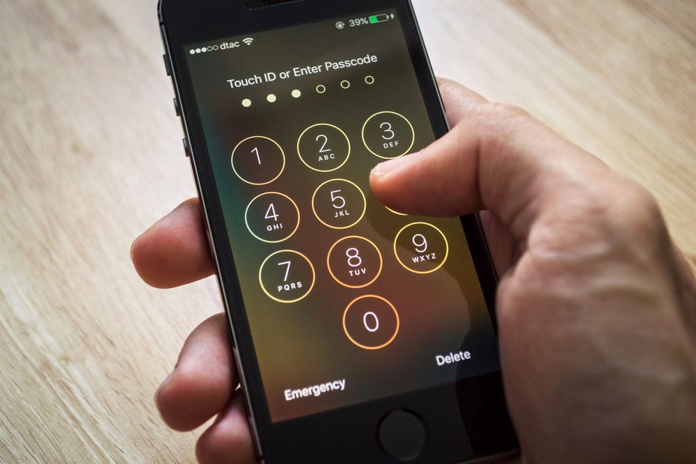 An iPhone&#039;s lockscreen with someone&#039;s thumb attempting to enter the passcode.