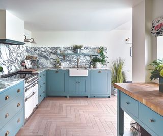 Blue draws, wooden counter top kitchen island, white and grey tile backsplash