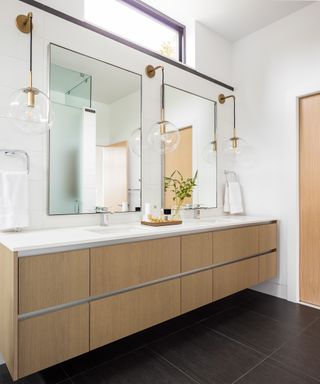 A double vanity unit with two built in sinks in a large bathroom with storage beneath and matching mirrors above